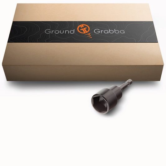 A black hex driver socket with a shank, designed to fit GroundGrabba stakes and ground anchors, displayed next to its packaging box which has 'Ground Grabba' branding.